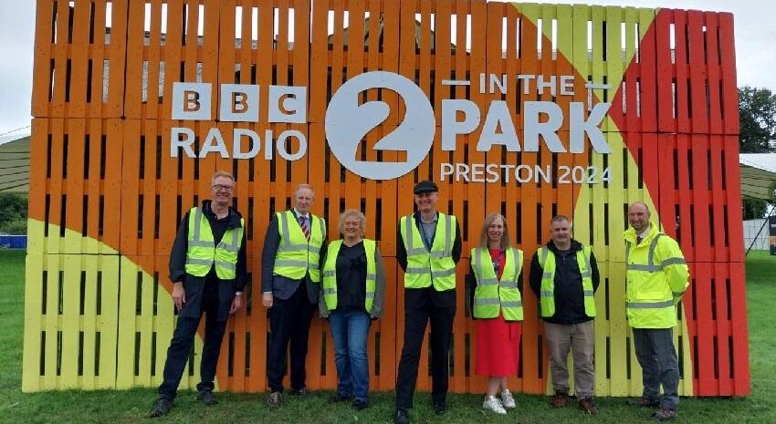 Preston City Council staff in front of Radio 2 in the Park sign