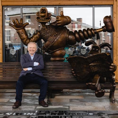 Nick Park sat on the Wallace and Grommit bench  in Preston in Spetember 2021.