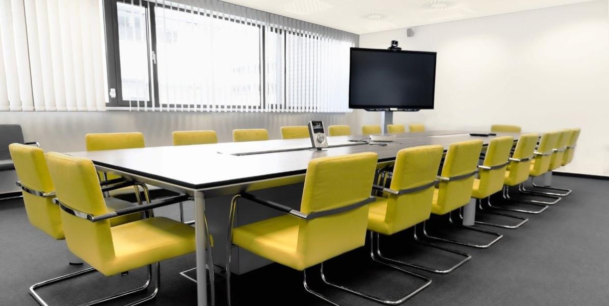 Meeting room with large table and yellow chairs